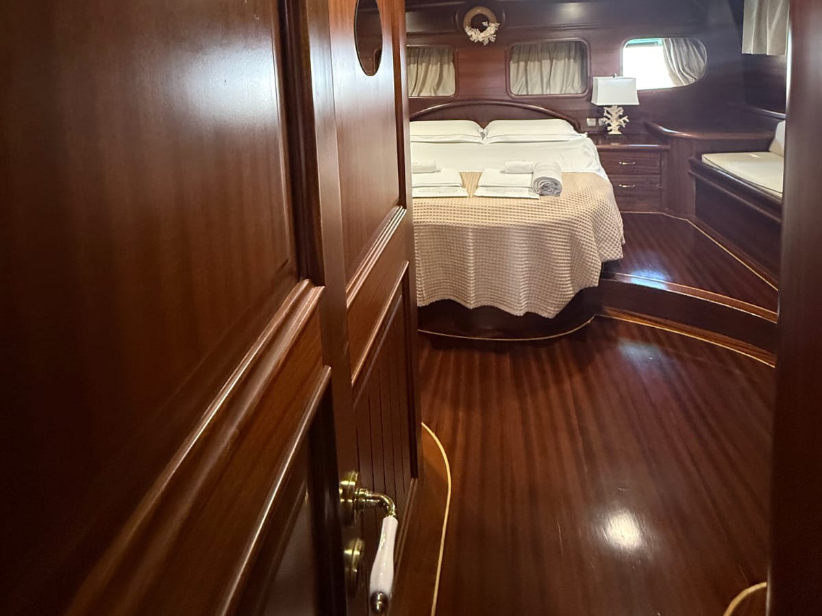Ingresso cabina armatoriale. ampio letto con accesso laterale, divanetto, grandi oblò di poppa, comodini e abat-jour in corallo